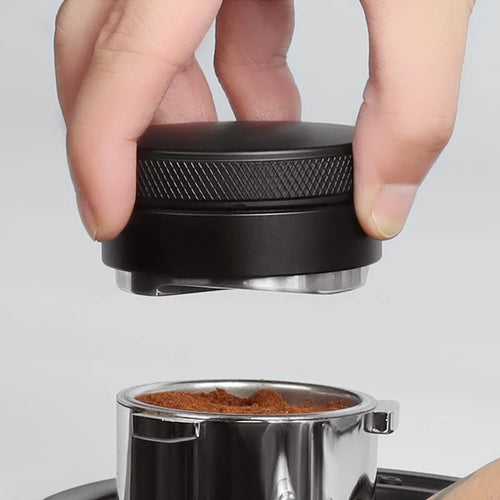 Lowering the distributor onto a mound of freshly ground coffee in a portafilter