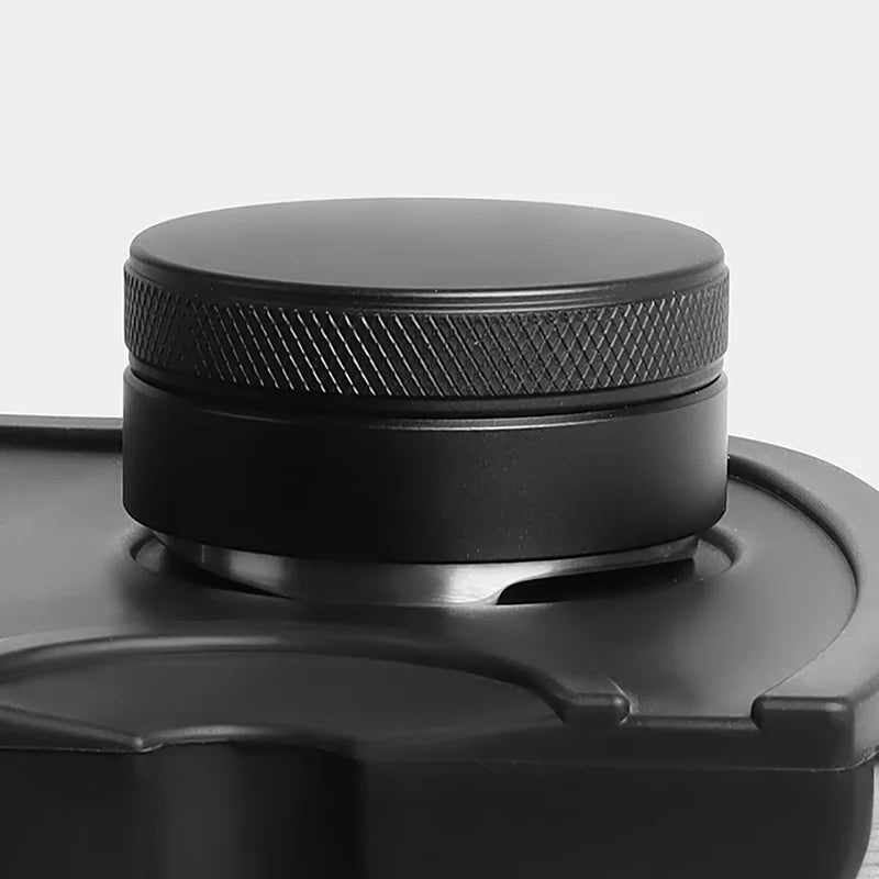 The distributor sitting in a portafilter on a tamping mat, knurled grip on top