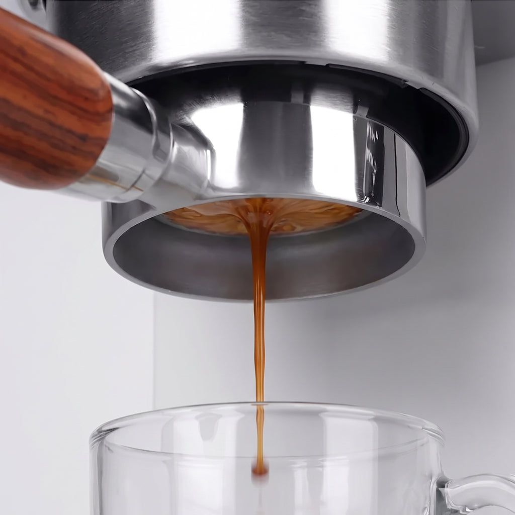 Espresso extracting from a 54mm bottomless portafilter into a glass