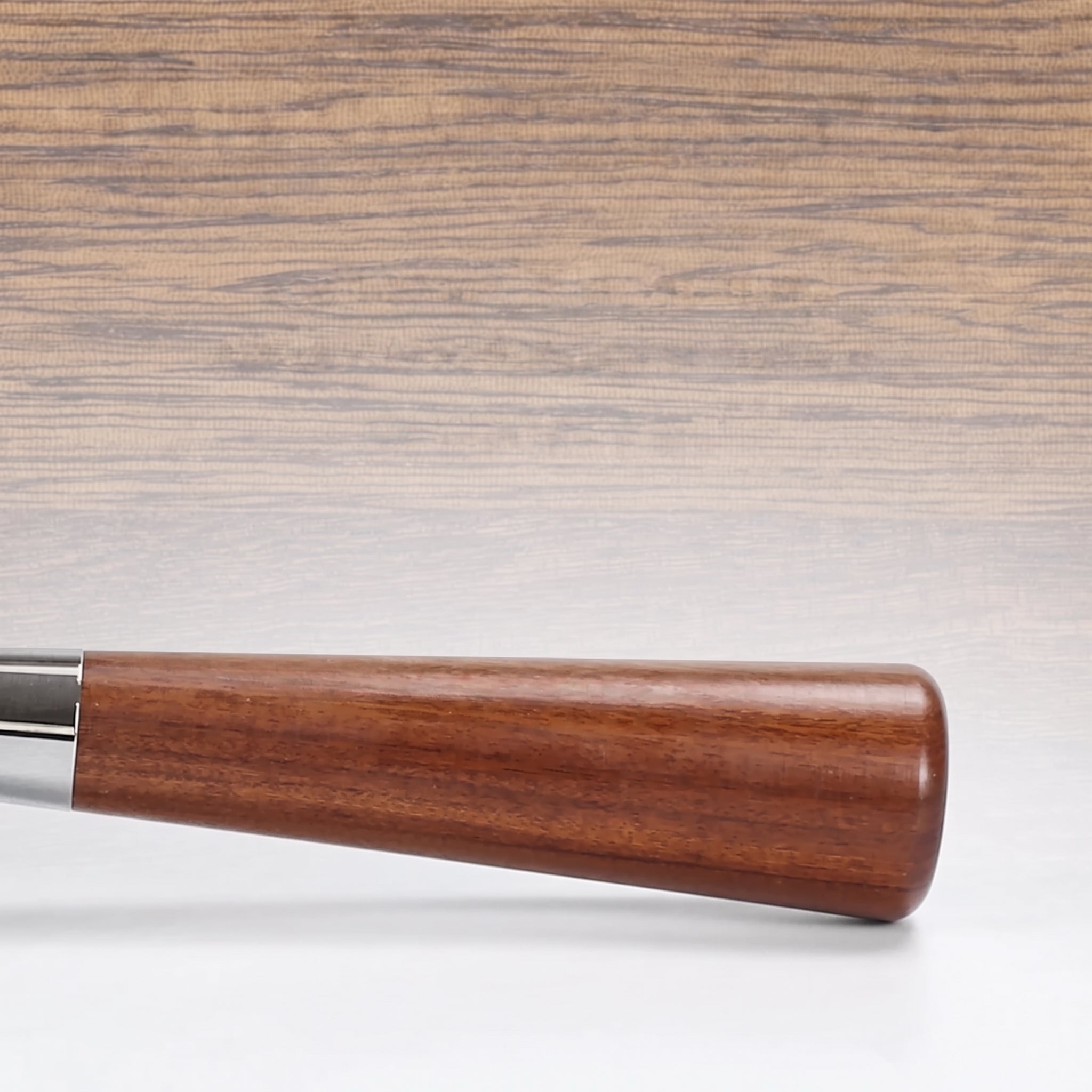 Close-up of the solid reddish-brown wooden handle and chrome ferrule